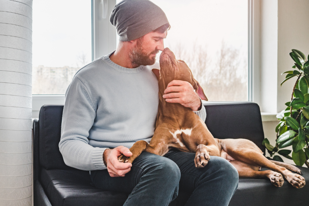 Man cuddling his dog 